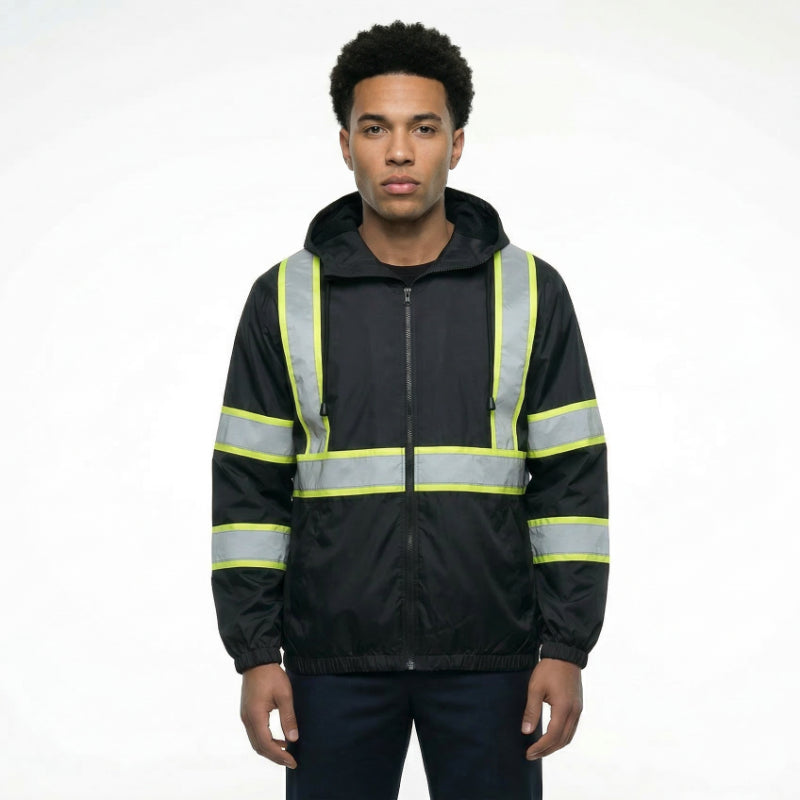 Person wearing a black safety jacket with reflective yellow stripes on a white background